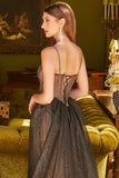 Woman in a black evening gown with a high slit standing in an elegant room.