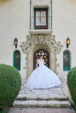 Woman in a white wedding dress standing in front of an ornate building entrance.