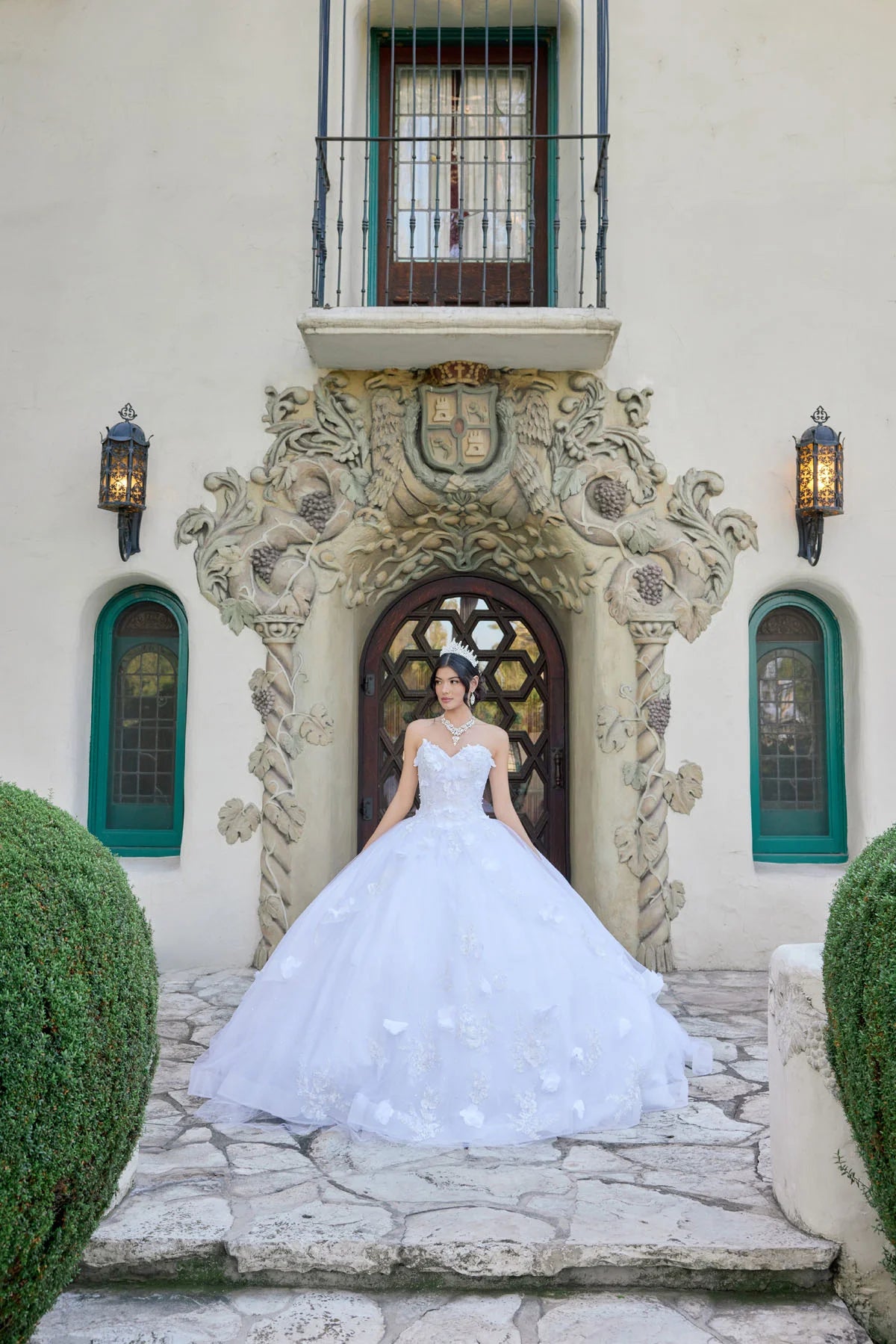 Woman in a white wedding dress standing in front of an ornate building entrance.