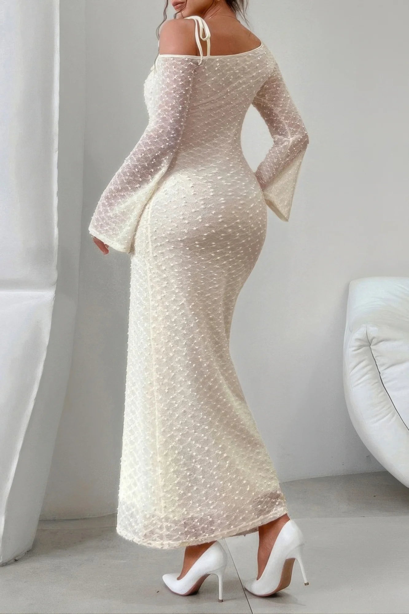 Beige off-shoulder dress with long sleeves in a minimalistic setting